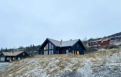 a house sitting on top of a snow covered hill at Amazing Home In Røn With Sauna in Ron