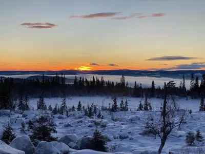a snowy field with a sunset in the background at TexasToppen, cabin in Hafjell with sauna in Hafjell