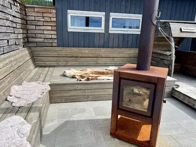 a dog laying on a deck with a fireplace at TexasToppen, cabin in Hafjell with sauna in Hafjell