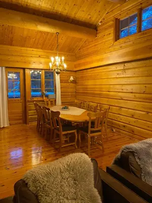 a dining room with a table and chairs in a cabin at Holmøy Lodge in Holmøyane