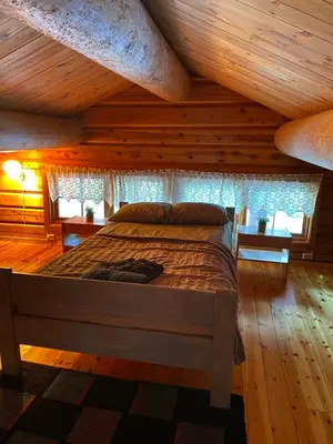 a bedroom with a bed in a room with wooden ceilings at Holmøy Lodge in Holmøyane
