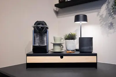 a black table with a lamp and plants on it at Nordic Nook - Modern downtown apartment in Ålesund