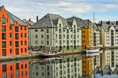 a group of buildings next to a river with boats at Nordic Nook - Modern downtown apartment in Ålesund
