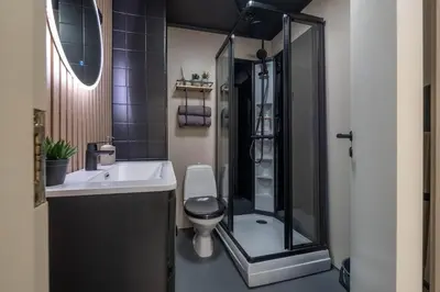 a bathroom with a shower and a toilet and a sink at Nordic Nook - Modern downtown apartment in Ålesund