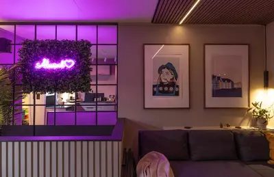 a living room with a couch and purple lighting at Nordic Nook - Modern downtown apartment in Ålesund