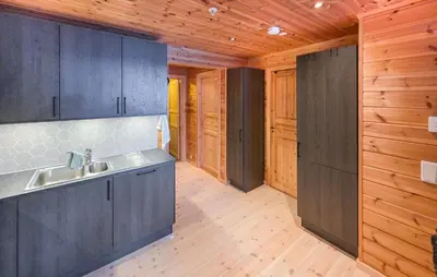 a kitchen with gray cabinets and wooden walls at Beautiful Apartment In Bjorli With Sauna in Bjorli