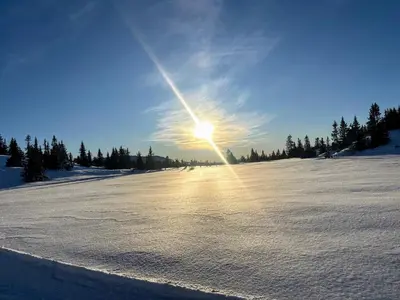 a snow covered field with the sun in the sky at Fjellspa med Fantastisk utsikt og Høy standard in Aurdal