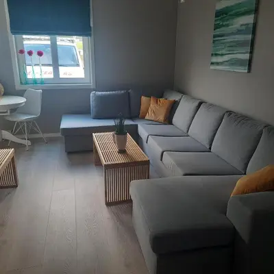 a living room with a couch and a table at Liten leilighet in Lii