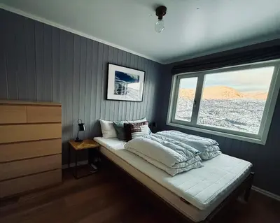 a bedroom with a bed and a large window at Hemsedal, Ski-in ski-out, Skarsnuten Panorama in Hemsedal