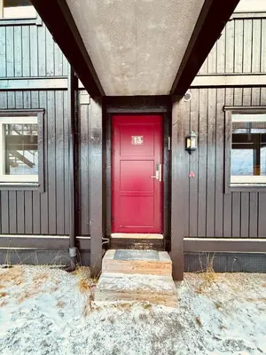 a red door on the side of a building at Hemsedal, Ski-in ski-out, Skarsnuten Panorama in Hemsedal