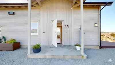 an open door of a building with two potted plants at Ocean view and jacuzzi in Forland