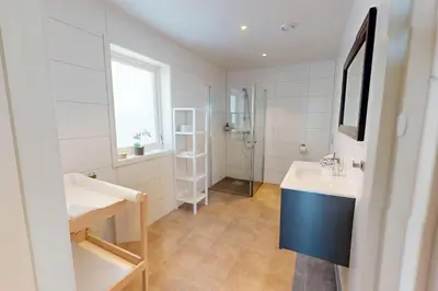 a white bathroom with a sink and a shower at Ocean view and jacuzzi in Forland