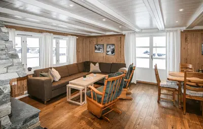a living room with a couch and a table at Lovely Home In Sjusjøen With Sauna in Sjusjøen
