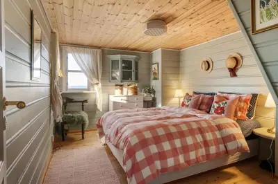 a bedroom with a bed and a wooden ceiling at Bekkeblom, family cabin with extension in Hafjell in Hafjell