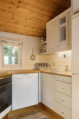 a kitchen with white appliances and a wooden ceiling at Bekkeblom, family cabin with extension in Hafjell in Hafjell
