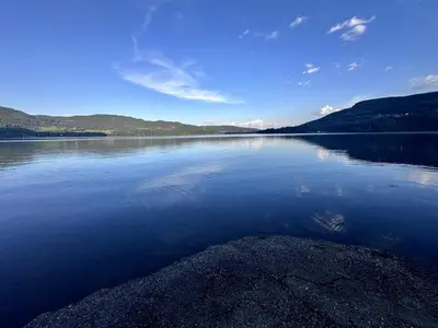 a large body of water with mountains in the background at A Cozy Nordic Home in Ålset
