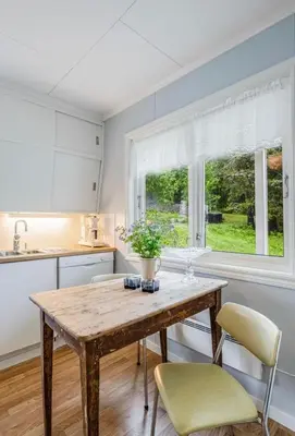 a kitchen with a wooden table and chairs and a window at A Cozy Nordic Home in Ålset