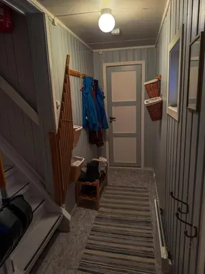 a hallway with a staircase and a door and a stairwayuggestuggest at Charming Norwegian Cottage in Lyngen