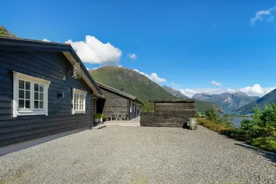 a house with a gravel driveway next to a building at Luxury cabin with amazing views in Stryn