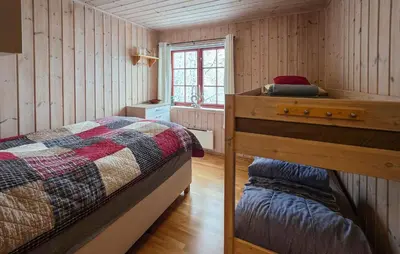 a bedroom with a bed and a dresser and a window at Amazing Apartment In Edland With House Sea View in Nesland