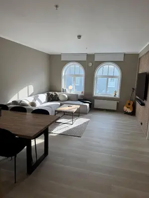 a living room with a couch and a table at Bright and modern city center apartment in Ålesund
