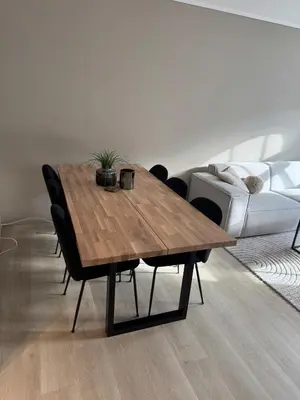 a wooden table in a living room with a couch at Bright and modern city center apartment in Ålesund