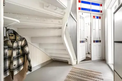 a hallway with white stairs and a stair case at Classic apartment with good standard in the city center in Trondheim