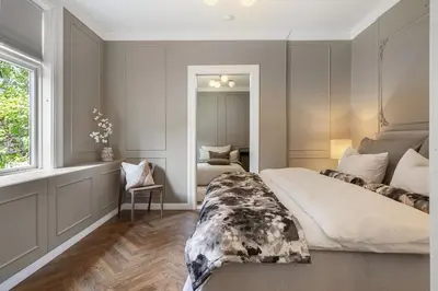 a bedroom with a large bed and a chair at Classic apartment with good standard in the city center in Trondheim