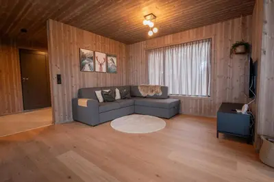 a living room with a couch and a window at Luxury cabin, Wellness and view over the Tyrifjord in Vikersund