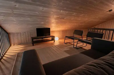 a living room with a couch and a tv at Luxury cabin, Wellness and view over the Tyrifjord in Vikersund