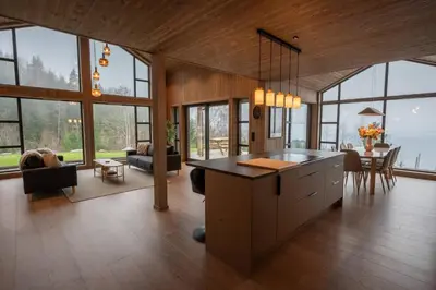 a kitchen with a island in a room with windows at Luxury cabin, Wellness and view over the Tyrifjord in Vikersund