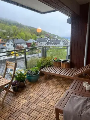 a patio with a bench and potted plants on a balcony at Newly renovated 3-room apartment in Bergen