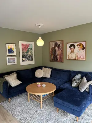 a living room with a blue couch and a table at Newly renovated 3-room apartment in Bergen