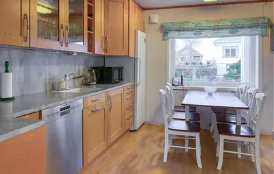 a kitchen with a table and a small table and chairs at Nice Home In Harøya With Harbor View in Steinshamn
