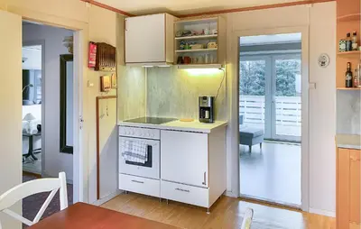 a kitchen with a stove and a white counter top at Nice Home In Harøya With Harbor View in Steinshamn