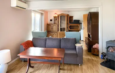 a living room with a couch and a table at Nice Home In Harøya With Harbor View in Steinshamn