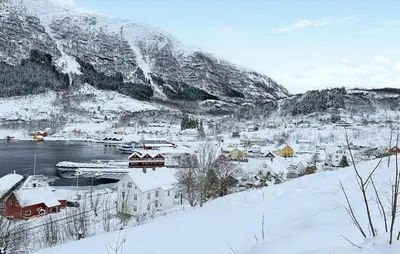 a small town in the snow next to a mountain at Cozy Home In Stongfjorden With House Sea View in Stongfjorden