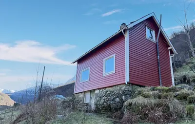 a red house sitting on top of a hill at Cozy Home In Stongfjorden With House Sea View in Stongfjorden