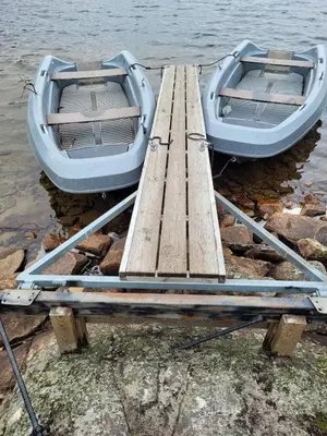 two boats are tied to a dock in the water at Family-friendly cabin at Høgevarde! in Flå