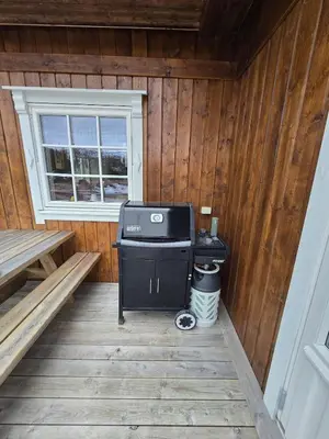 a small stove in a cabin with a window at Family-friendly cabin at Høgevarde! in Flå