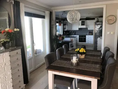 a dining room with a table and chairs and a kitchen at House with oceanview, 4 bedrooms, close to Bergen in Alversund