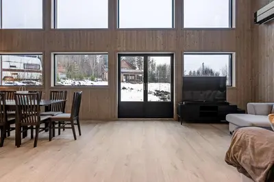 a living room with a table and chairs and a tv at Vestbyvegen 34A By Vacation Trysil in Trysil