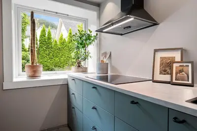 a kitchen with blue cabinets and a window at Cozy Apartment in Bergen in Bergen
