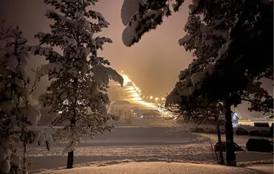 a row of snow covered trees with the sunset in the background at Lovely Home In Bjorli With Sauna in Bjorli
