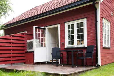 a red house with chairs and a table on a deck at Rjukan Hytteby in Rjukan