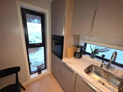 a kitchen with a sink and two windows at House with great location in Trysil
