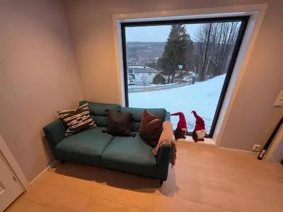 a green couch in a room with a large window at House with great location in Trysil