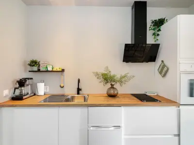 a kitchen with white cabinets and a counter top with a sink at 3FF - Newly renovated studio apt in the middle of the city centre in Trondheim