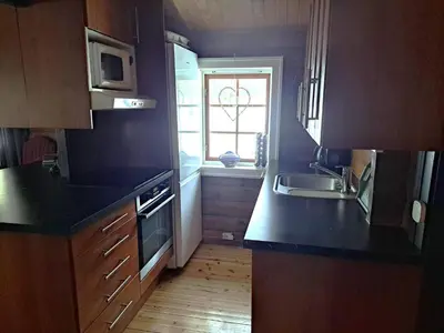 a kitchen with black counters and a sink and a window at 8 person holiday home in Jordet in Jordet