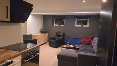 a kitchen and a living room with a couch at Apartament Vigra Fjord in Synes